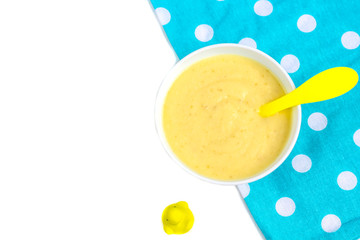 Healthy breakfast porridge for kids. Bowl of baby food on a fabric isolated on white. The concept of proper nutrition and healthy food.
