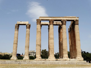 Fototapeta premium Temple of Olympian Zeus in Athens in Greece with The Parthenon Temple on hill in sight. Temple of Olympian is also known as the Columns of the Olympian Zeus.