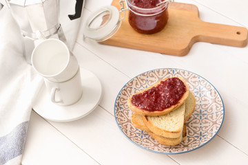 Plate with toasted bread and sweet jam on white table