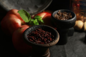 bowl with tobacco for hookah. fruits on a black background. smoke hookah