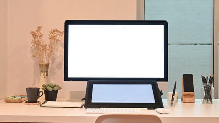 Mockup tablet and computer on creative workspace with warm light.