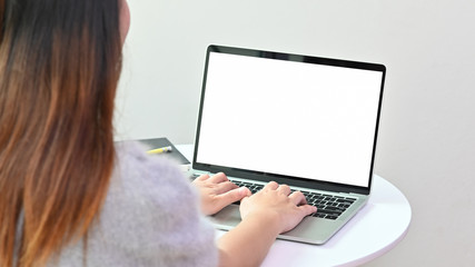 young woman's typing laptop computer, Mockup blank screen with behind photo shot.