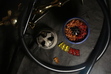 Fototapeta na wymiar bowl with tobacco for hookah. fruits on a black background