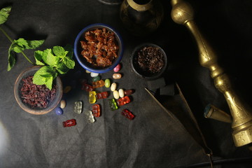bowl with tobacco for hookah. berries on a black background