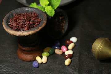 bowl with tobacco for hookah. berries on a black background