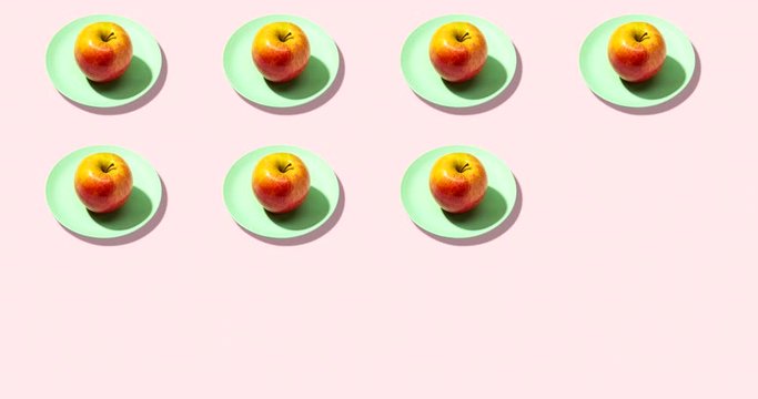 Fresh apples in plate on pink background. Vibrant colorful pattern video stop motion