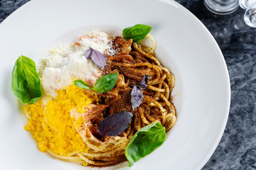Top view Delicious carbonara pasta with salted yolk, spices and basil. Mediterranean and italian cuisine. Restaurant food for lunch. Close up. Food photography