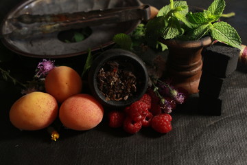 bowl with tobacco for hookah. fruits on a dark background. smoking shisha