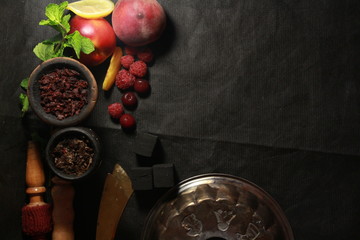 bowl with tobacco for hookah. berries on a black background