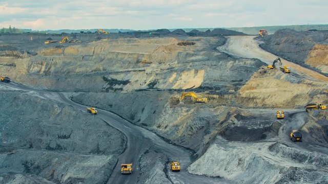 Timelapse open pit coal mining. Yellow dump trucks drive with coal