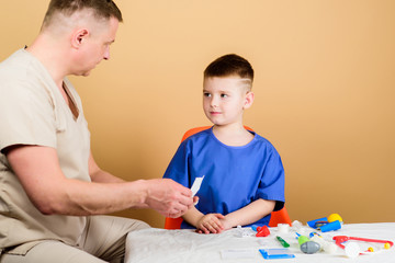 Obraz na płótnie Canvas family doctor. trust and values. small boy with dad in hospital. happy child with father with stethoscope. medicine and health. father and son in medical uniform. family trust. child trust his father