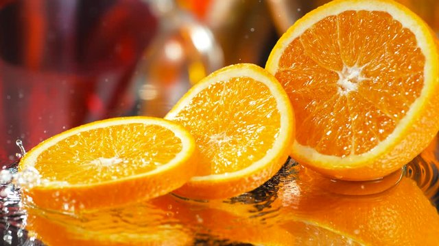 Water splash on halved orange. Shot with high speed camera, phantom flex 4K. Slow Motion.