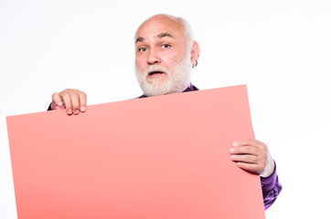 Senior holding blank sign board and looking at camera. Elderly people. Man bold head and gray beard hold poster for advertisement copy space. Senior means experienced. Senior man recommend something