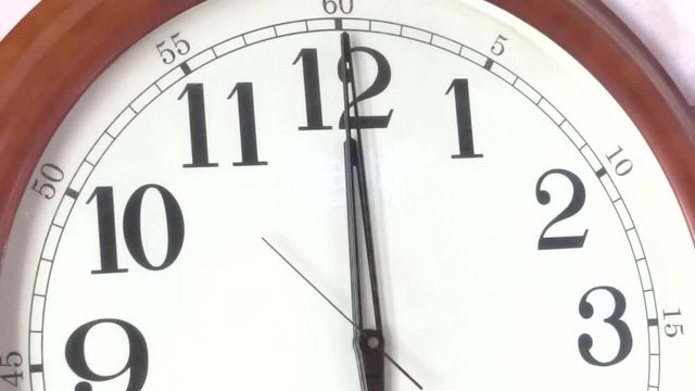 Close-up of a vintage clock face at 12 o'clock with a second hand moving