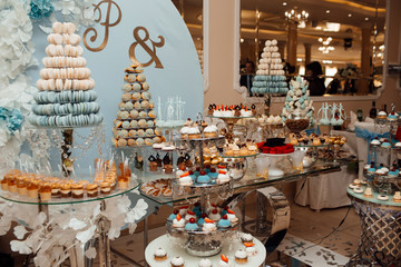 Candy bar with balls, macaroon, candy bar on holiday, candy bar at the wedding. Dessert table for a party. Cakes, cupcakes. Delicious sweets on candy buffet.  