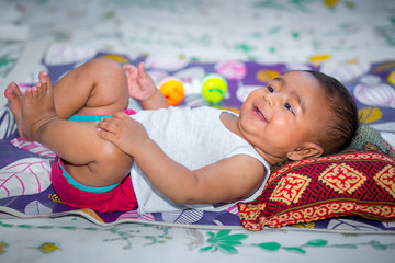 A baby looking and smiling at home.