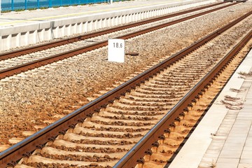 Train on platform in station in Czech Republic. Railroad tracks with concrete sleepers. Local railway station.