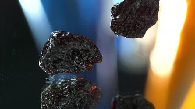 Close up of dried plums , dried prunes falling to the water table. SLOW MOTION, 4K, SLOW FOOD, SPLASH into the water
