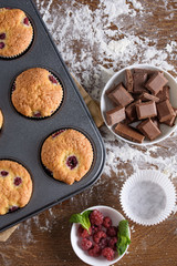 Delicious flavored cupcake with raspberries, white cream, and chocolate icing.
