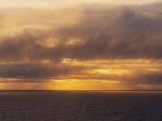 Obraz premium sunset over the sea surface, warm orange tones.