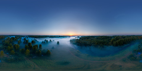 Fototapeta na wymiar 360-degree panoramic aerial view of the field, forest and river covered with a thick layer of morning fog