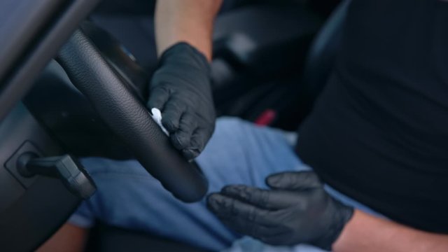 Car detailing. Steering wheel cleaning. Car wash worker works in gloves. Raw-video recording.