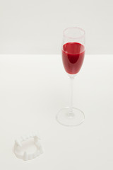 Bloody vampire drink for halloween with fangs on white background.