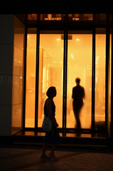 男性と女性のシルエットがオレンジ色のウィンドウで交叉する