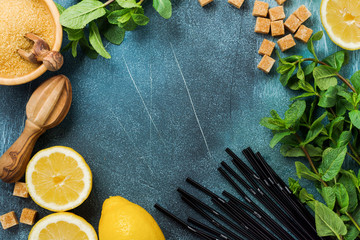 Concept with ingredients for homemade refreshing lemon juice lemonade, cane sugar, and mint on old concrete background.