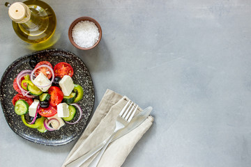Greek salad on a concrete background. Tomatoes, peppers, olives, cheese, onions. Healthy eating. Diet. Vegetarian food.