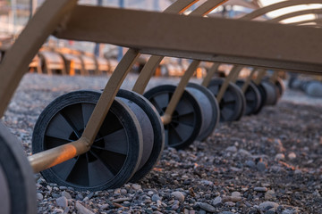 Fototapeta premium Wheels of empty, folded deck chairs. Close-up. Early morning, Turkey.