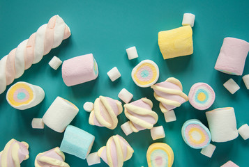 Natural marshmallows sweets on a blue background. Airy multicolored marshmallows sprinkled on the...