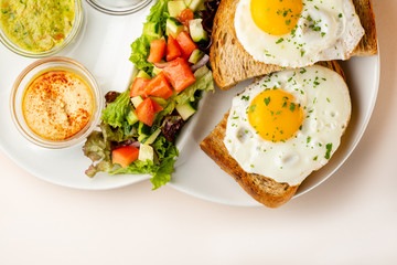 Breakfast fried eggs and salad top view