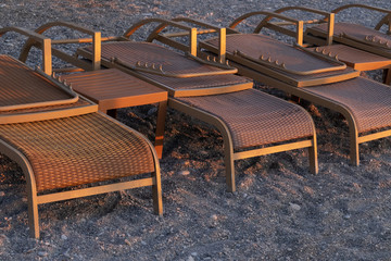 Empty deck chairs on a pebble beach. Mediterranean Sea, early morning. Turkey.