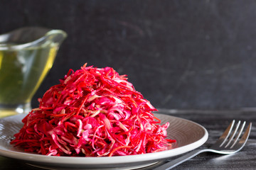 Raw beetroot, carrot and cabbage salad on black background