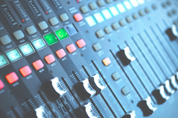 Audio mixer control panel with sliders in blur