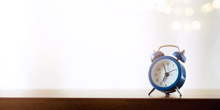 happy new day symbol; morning alarm clock against sunlight background