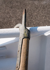 Close-up of mooring hook and boat railing.