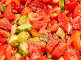 Background of chopped pieces of tomato, cucumbers and red sweet pepper
