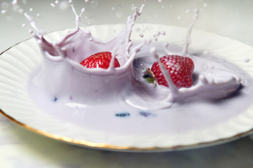 Slow motion of splashing with strawberry in fruit yogurt