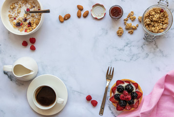 Breakfast with crunch, almond milk, fruits, jam, fruit cake, a cup of black coffee on a marble background. Top view. Copy space. Horizontal orientation.