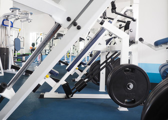 Fototapeta na wymiar Exercise machines in classic small gym, white interior, as a background