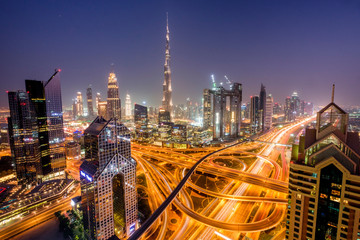 Fototapeta na wymiar Dubai cityscape at blue hour with cars and traffic on roads and Burj Khalifa