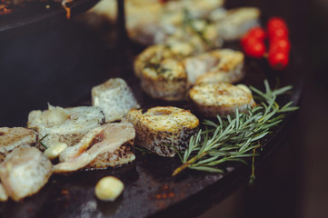 The chef is cooking fish on the grill. Golden, juicy and mouth-watering pieces of grilled fish, delicious food,