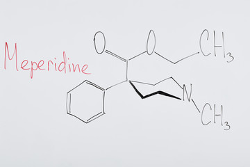 top view of white board with chemical formula and lettering meperidine