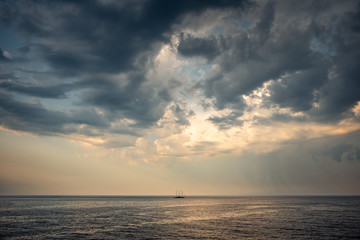 Naklejka na ściany i meble Moody clouds above lonely boat far out to sea off the coast of Croatia in the Adriatic Sea