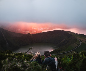 View of a couple from Hell Mouth viewpoint (Miradouro Boca do Inferno) in São Miguel Island,...
