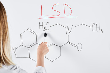 cropped view of woman pointing with marker at white board