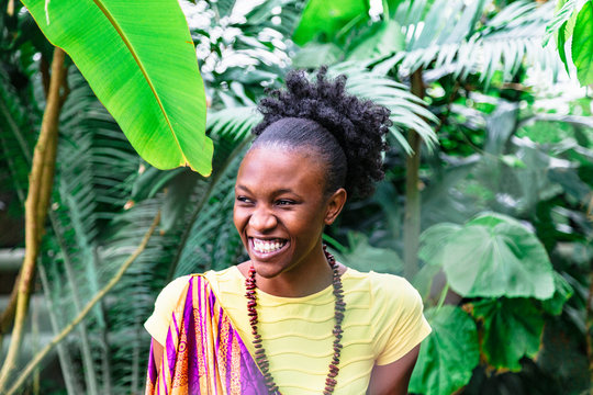 Smiling african girl on background of green plants