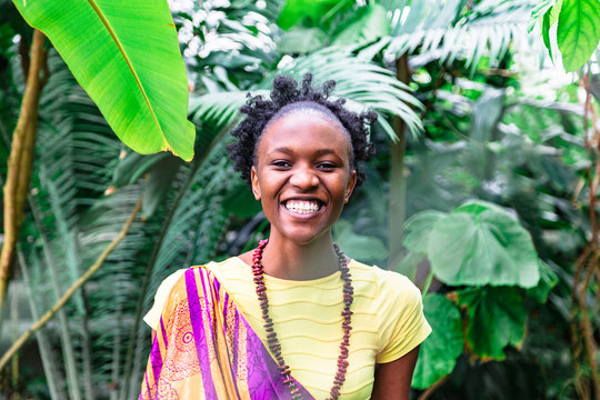 Smiling african girl on background of green plants